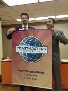 District 23 Director Tracy Thomason give the new club banner to UTEP Toastmasters President Saad Sheikh.