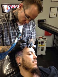 Photo by Michael Spear Ben Shaw tattoos customer Carlos Cordova at Archetype Tattoo in Albuquerque. Shaw chairs the New Mexico Board of Body Art Practitioners, which he helped create by testifying in Santa Fe during the 2015 state legislative session.